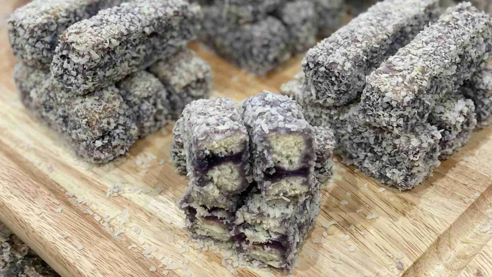 Filipino Ube Bars stacked on a wooden cutting board
