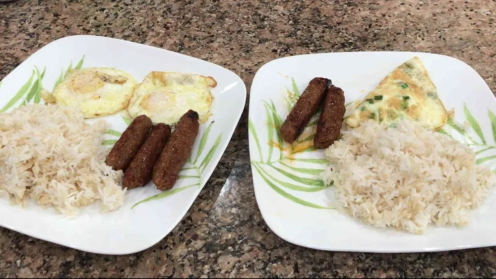 Two plates of rice with eggs Filipino Longanisa and eggs cooked.