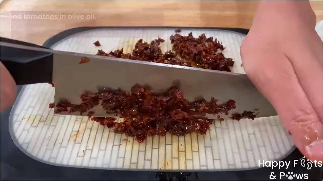 Chopping sundried tomatoes on a cutting board