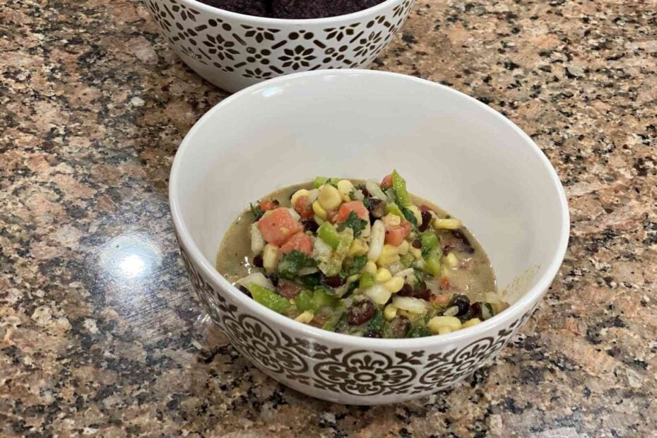 black bean salsa with corn, cilantro, onion, tomato, jalapeno, lime juice, and vinagrete in a bowl.