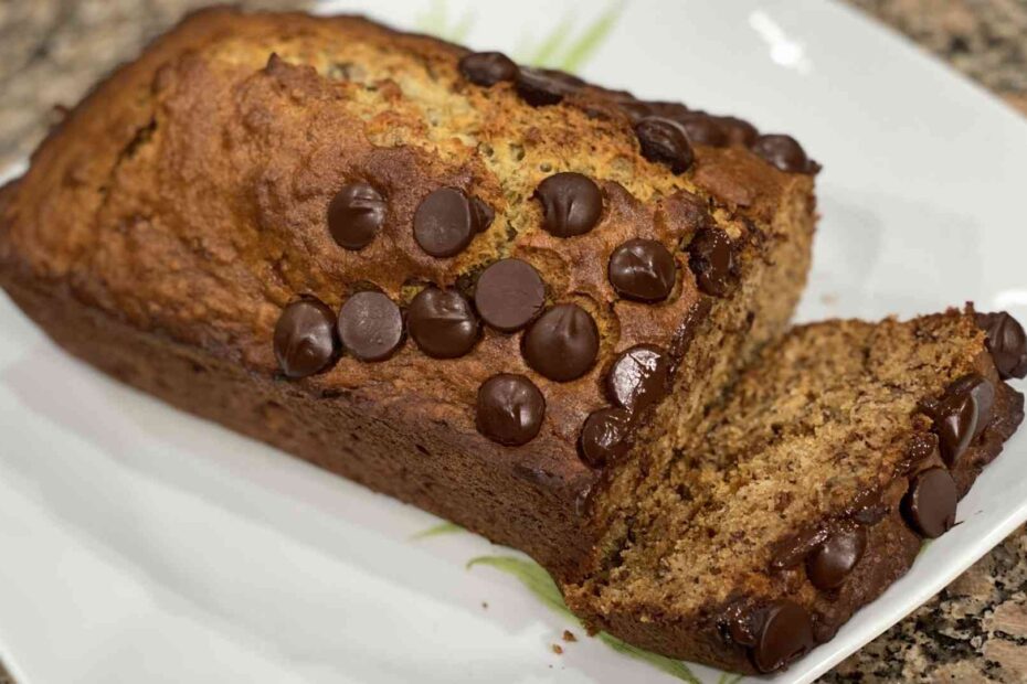 fresh baked banana bread on a plate with chocolate chips on top