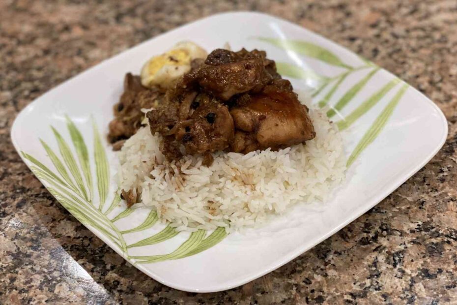 A plate with chicken, jasmin rice, eggs, and, pork filipino adobo