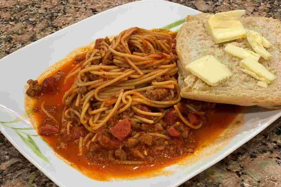 sweet filipino spaghetti with french bread, hotdog, and sausage.