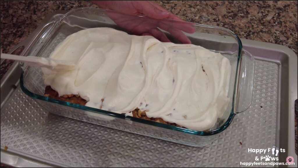 cream cheese frosting being spread on zucchini bread