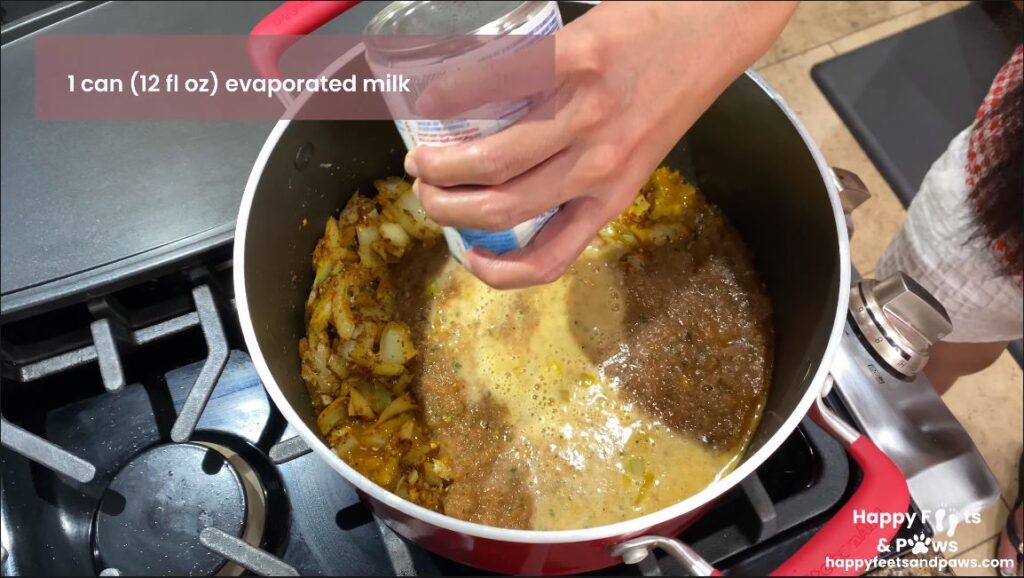 canned milk being added to a pot for chicken tikka masala recipe