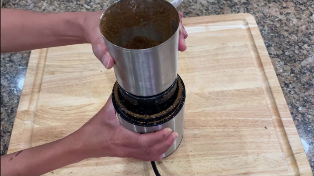 Ingredients being chopped and blended with a coffee grinder for garam masala recipe