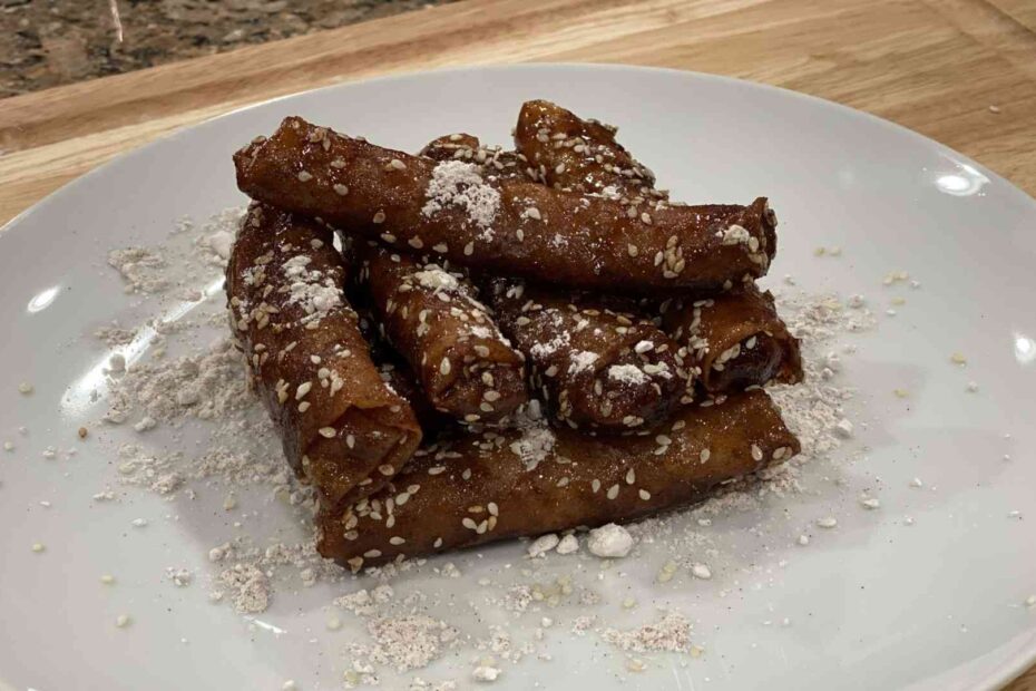 Banana Rum Rolls Stacked on a plate with powdered sugar