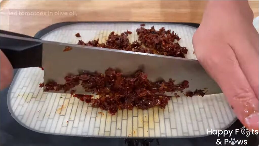 Chopping sundried tomatoes on a cutting board