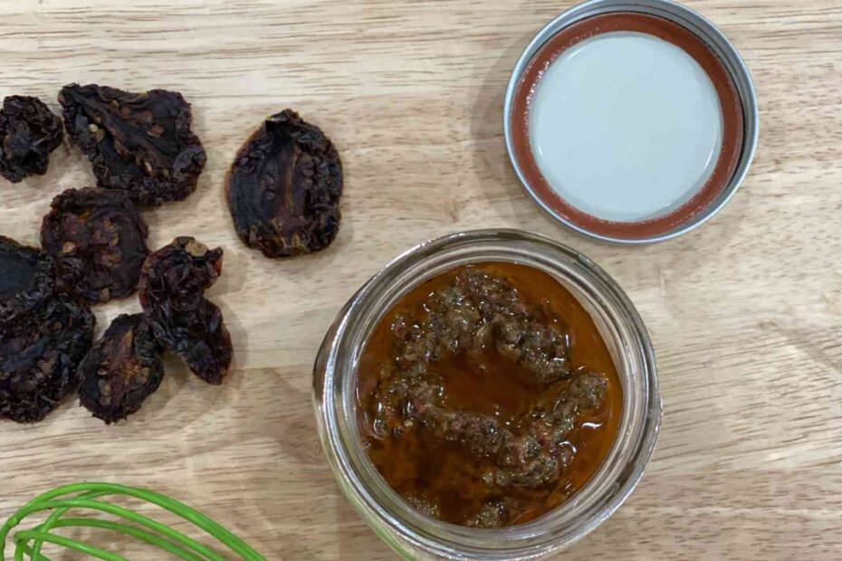Sun-Dried Tomato Vinaigrette in glass container next to sundried tomatoes