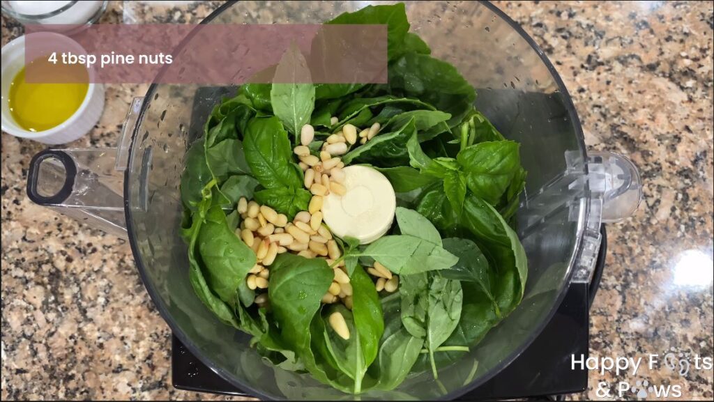 Fresh basil and pine nuts in a food processor for basil pesto