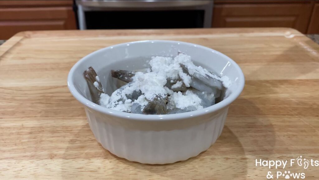 Raw tail on shrimp with corn flour in a bowl