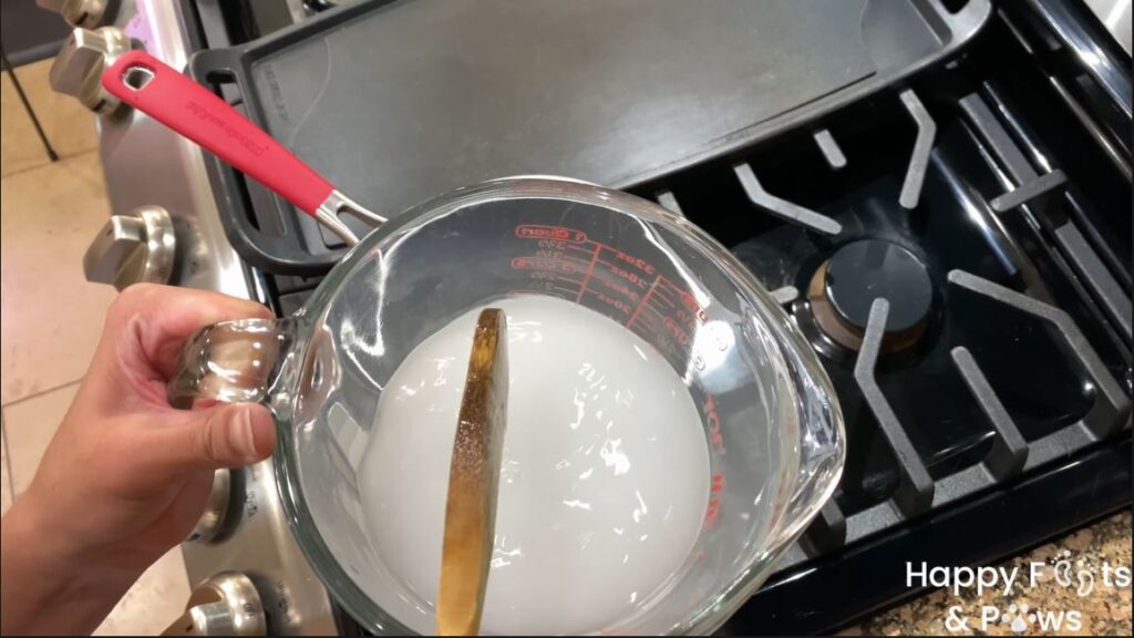 stirring ingredients in pyrex measuring glass for ube syrup