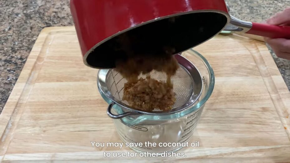 straining coconut milk curds with a screen over a measuring bowl